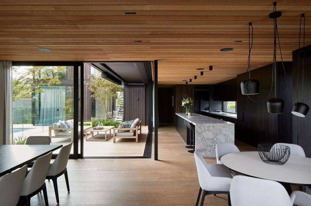 Cedar from Rosenfeld Kidson and Co. continues through to the interior. With expressed negative detailing, the cedar ceiling contrasts with the dark oak veneer cabinetry.
