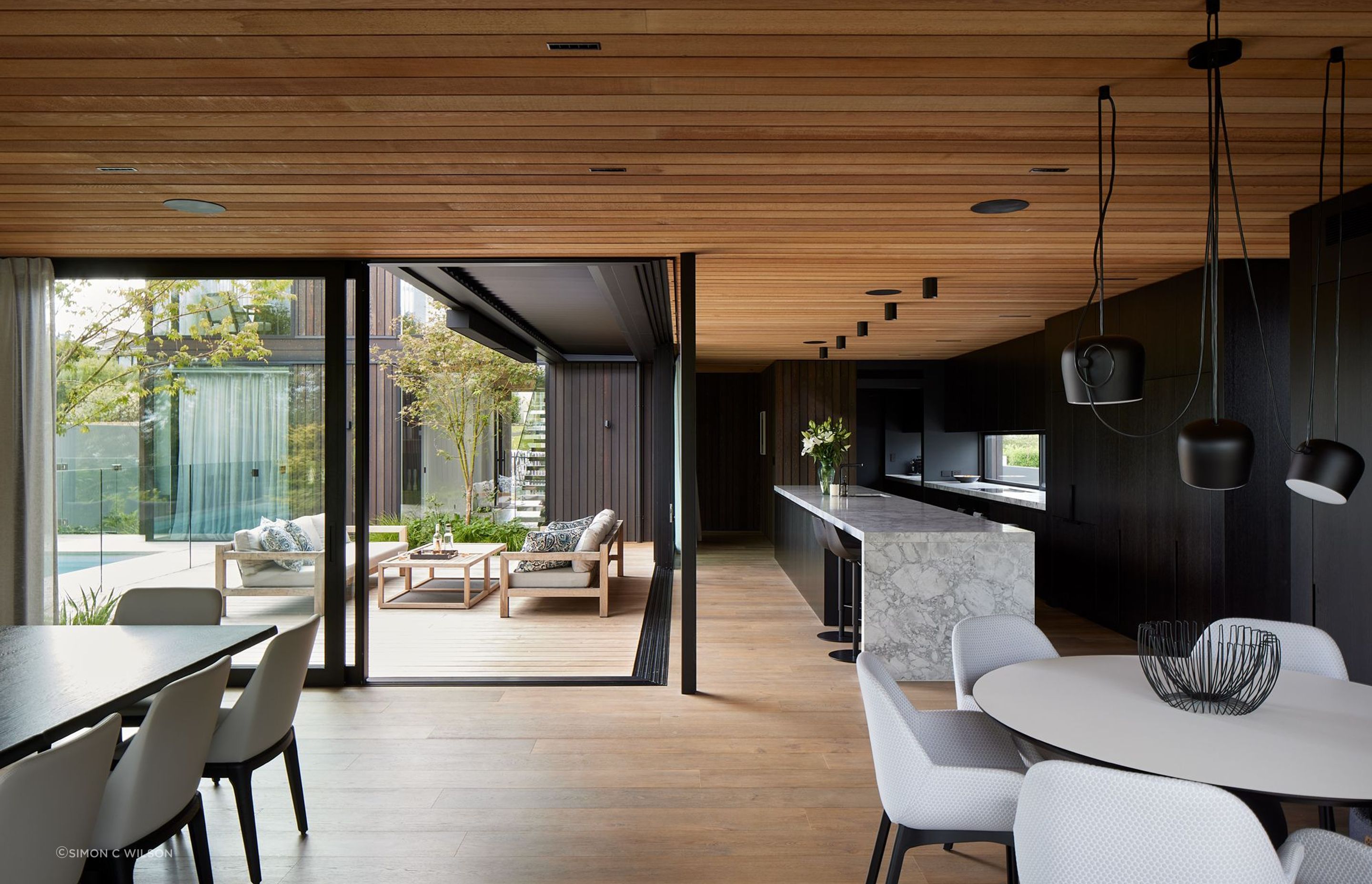 Cedar from Rosenfeld Kidson and Co. continues through to the interior. With expressed negative detailing, the cedar ceiling contrasts with the dark oak veneer cabinetry.