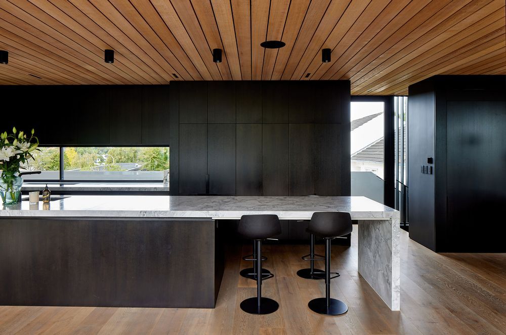 A granite island bench runs the length of the kitchen.