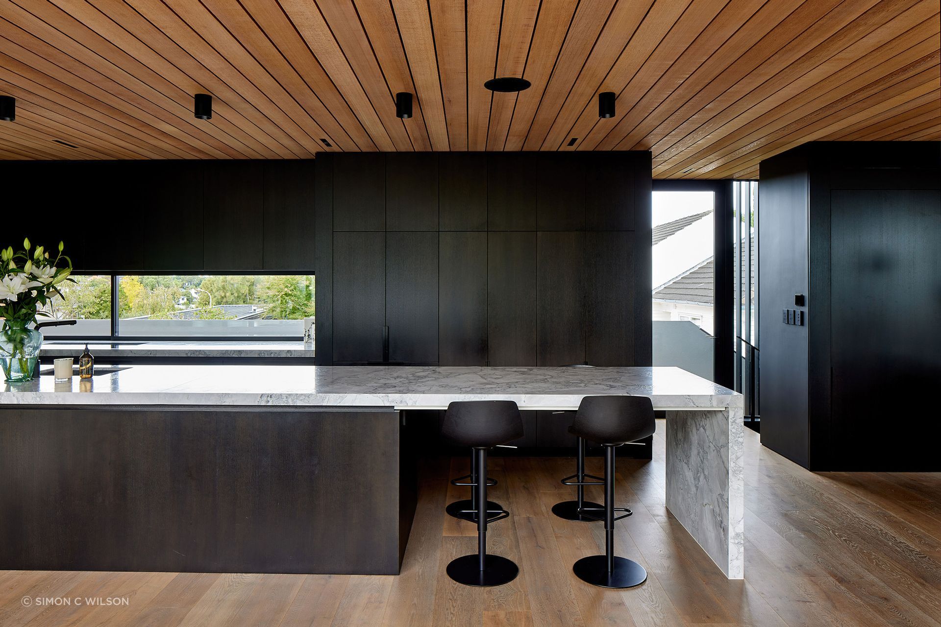 A granite island bench runs the length of the kitchen.