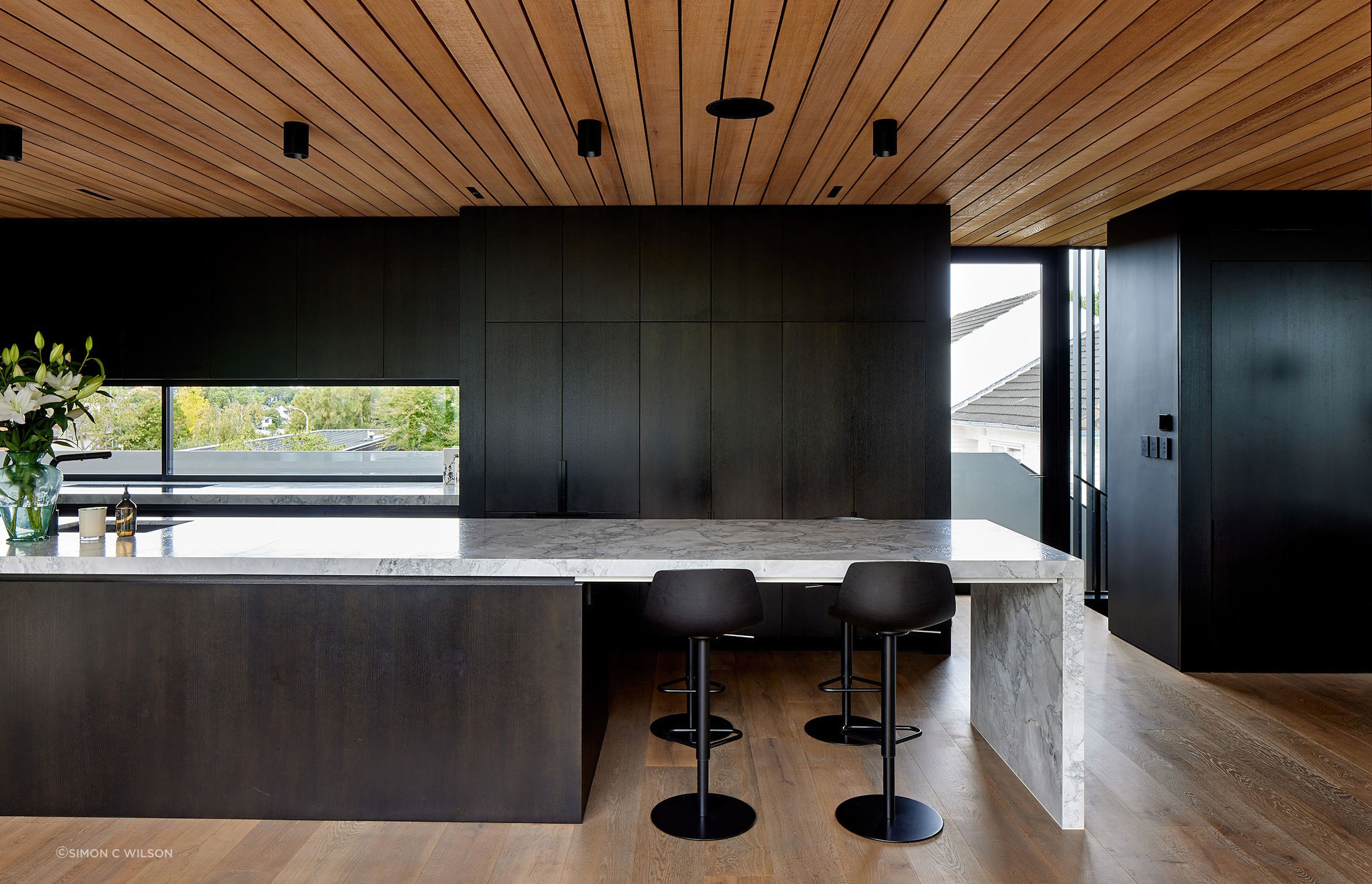 A granite island bench runs the length of the kitchen.
