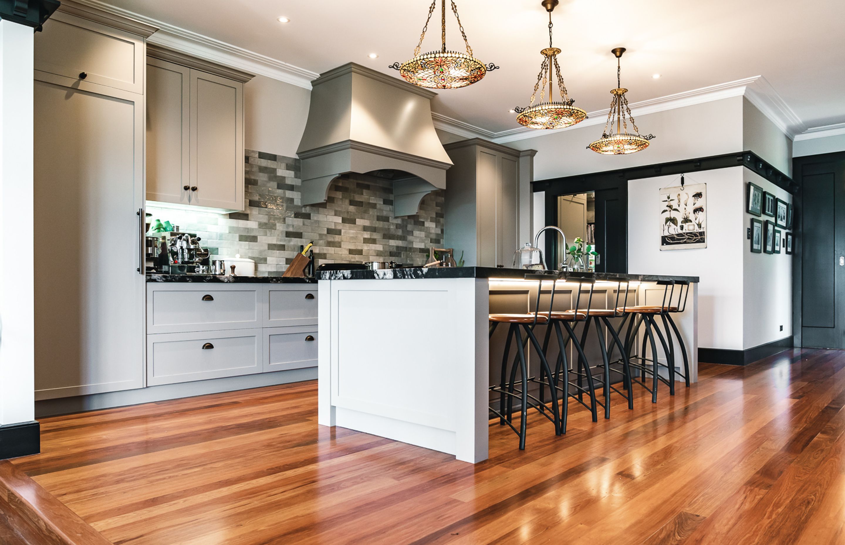 The kitchen features leathered granite benchtops from Stone Warehouse, with shaker style cabinets crafted by Neil Taylor Cabinetmaker & Design.
