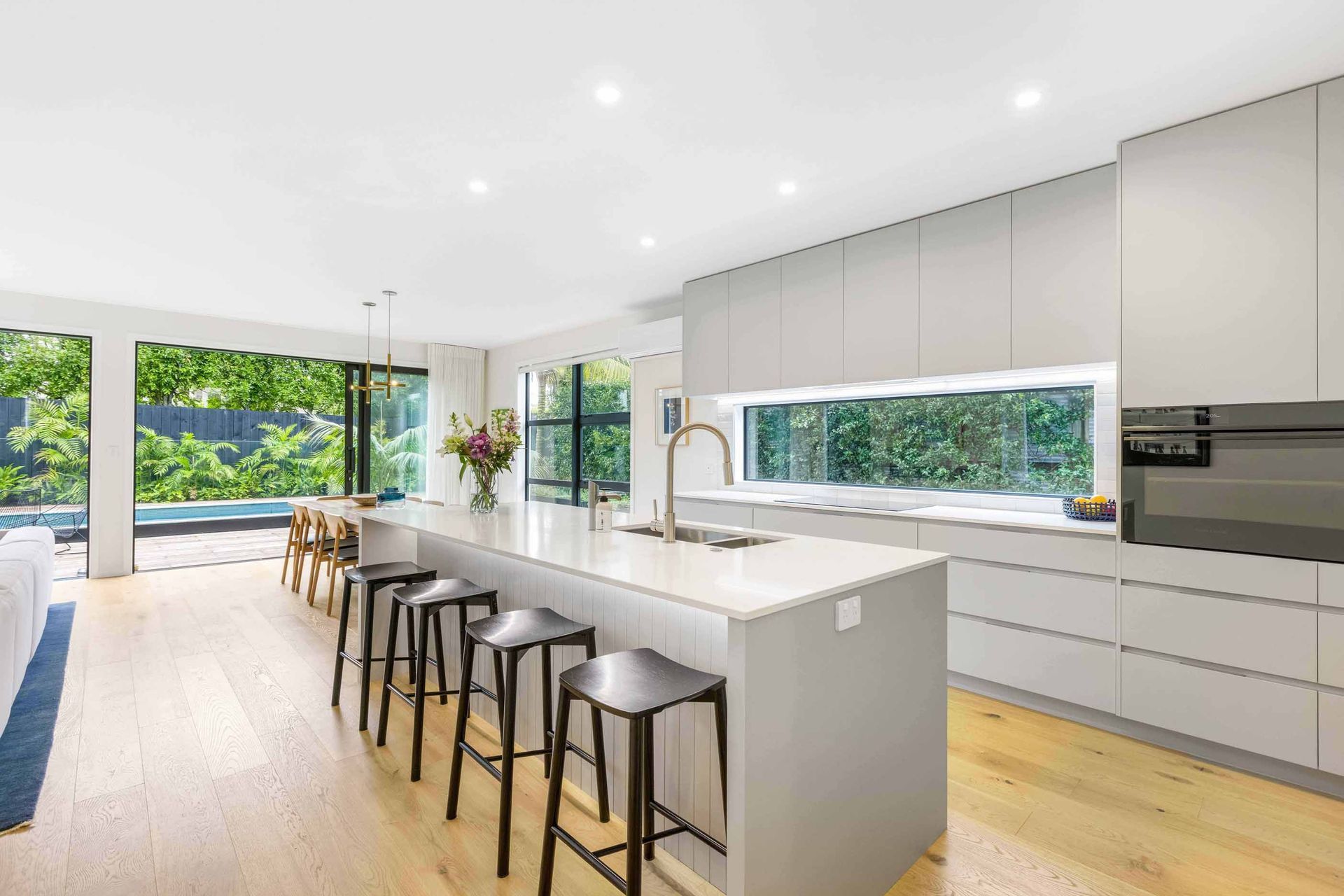 The kitchen and dining space flows seamlessly out to the outdoor living space and pool area.