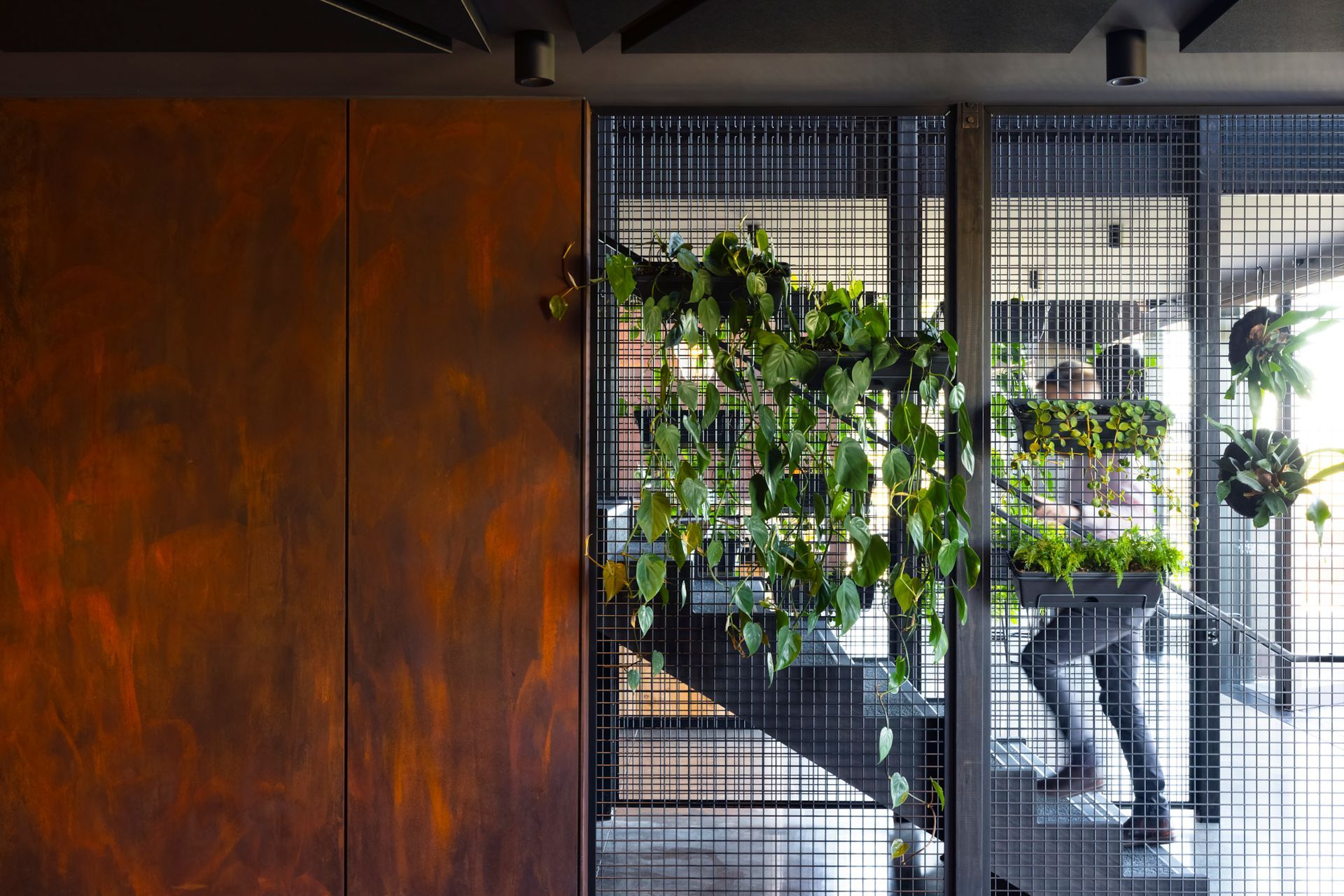 A central stair features wire mesh and Porter's Paints Liquid Iron and Instant Rust paint to reflect an industrial aesthetic.