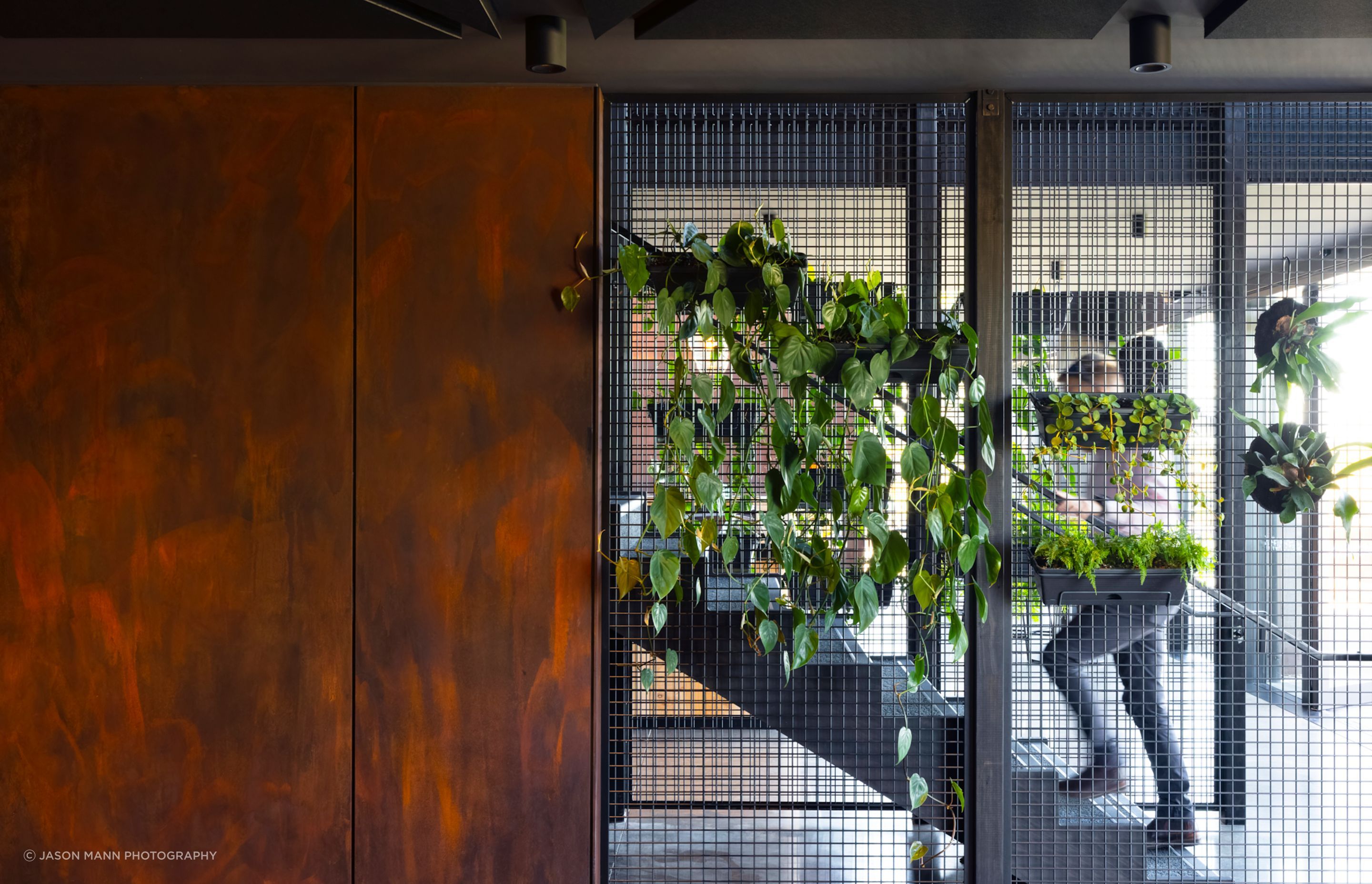 A central stair features wire mesh and Porter's Paints Liquid Iron and Instant Rust paint to reflect an industrial aesthetic.