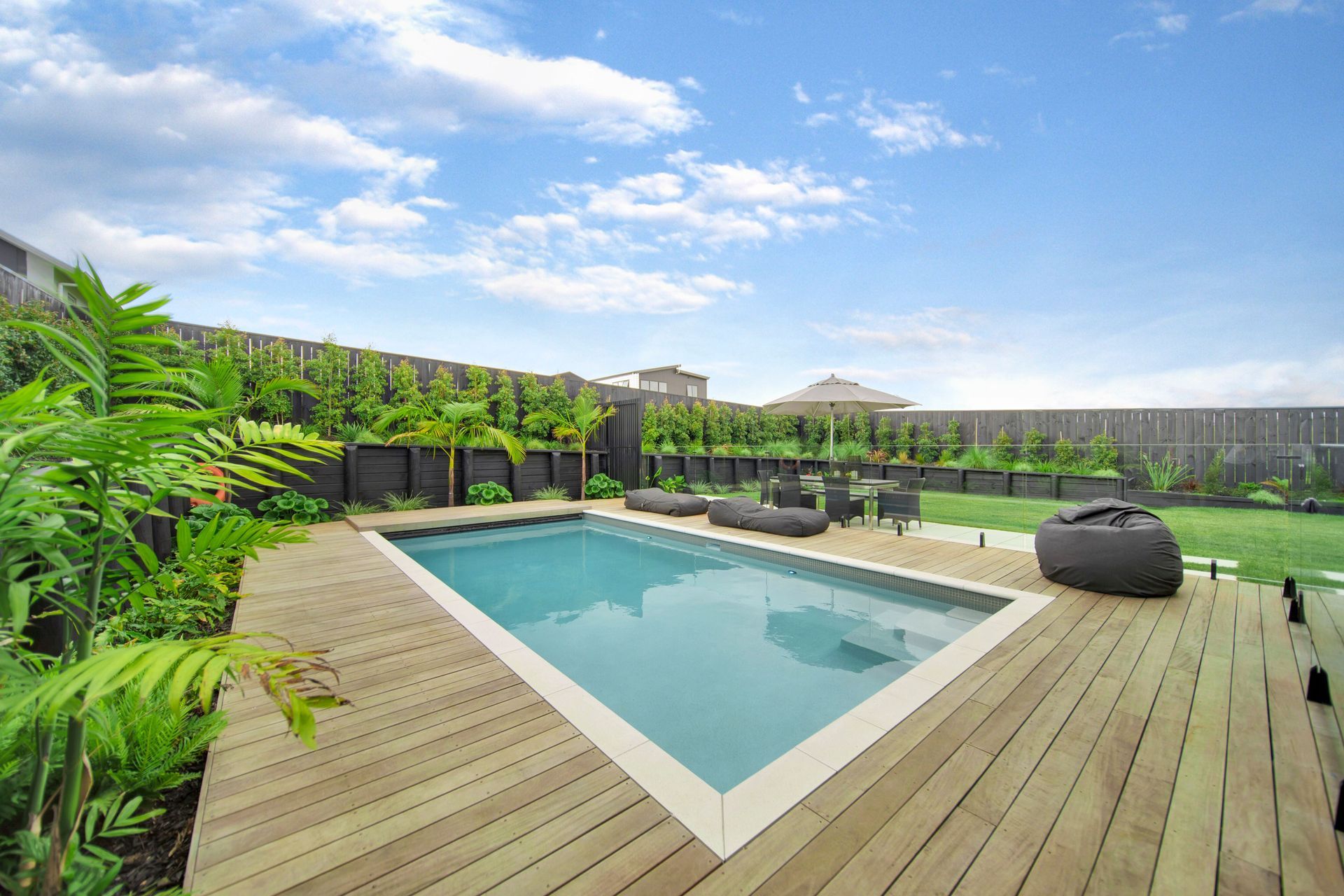 Hardwood decking surrounds the pool, installed by Lazaway Pools.