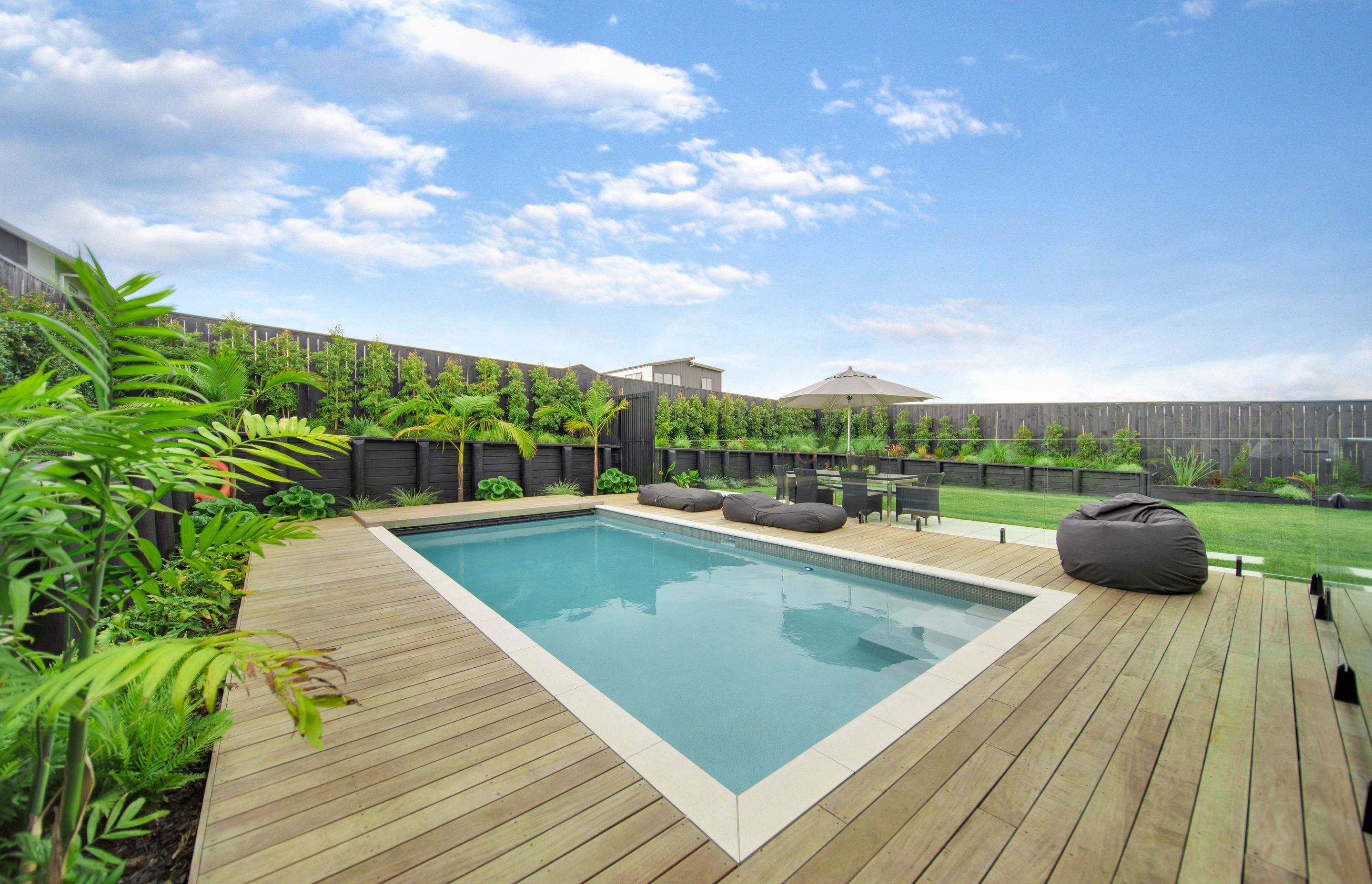 Hardwood decking surrounds the pool, installed by Lazaway Pools.