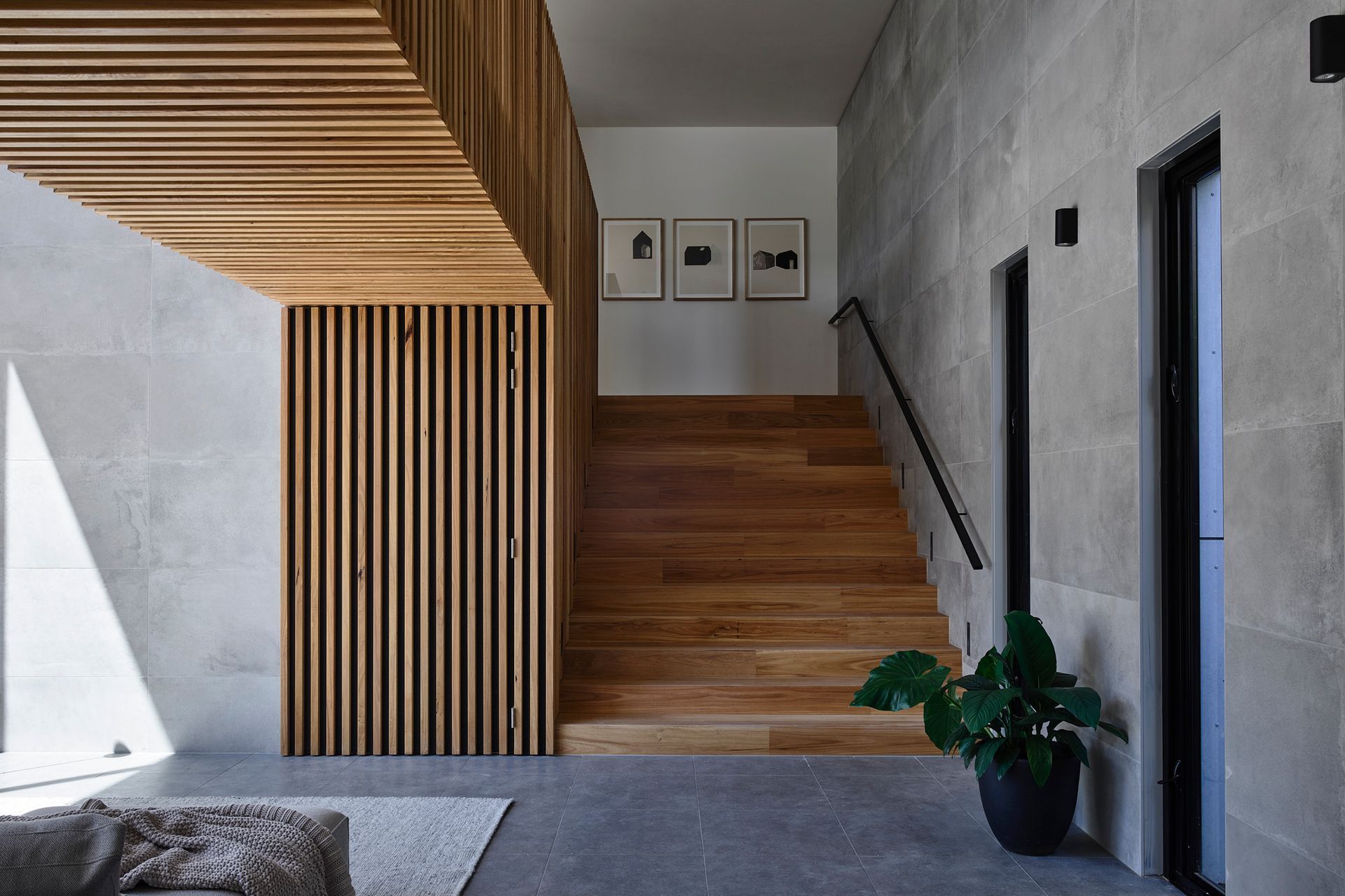 A neutral palette has been used for the home's interior. The wide timber staircase leads to the client's study nook.