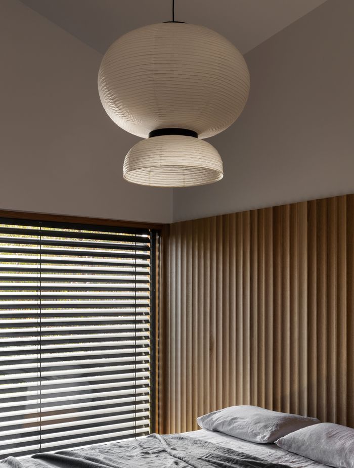 The wood paneling doubles as a bedhead in the main bedroom.