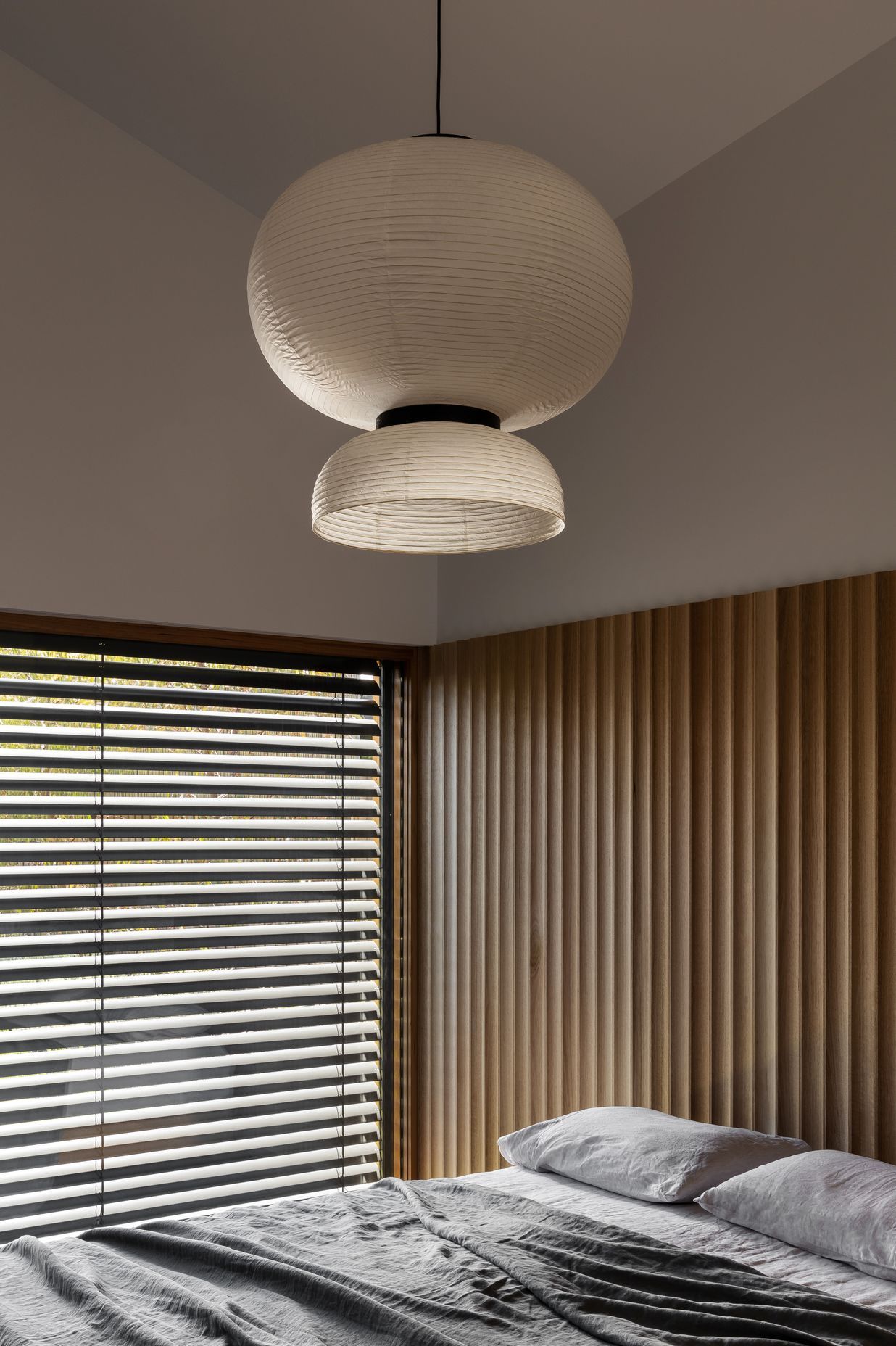 The wood paneling doubles as a bedhead in the main bedroom.