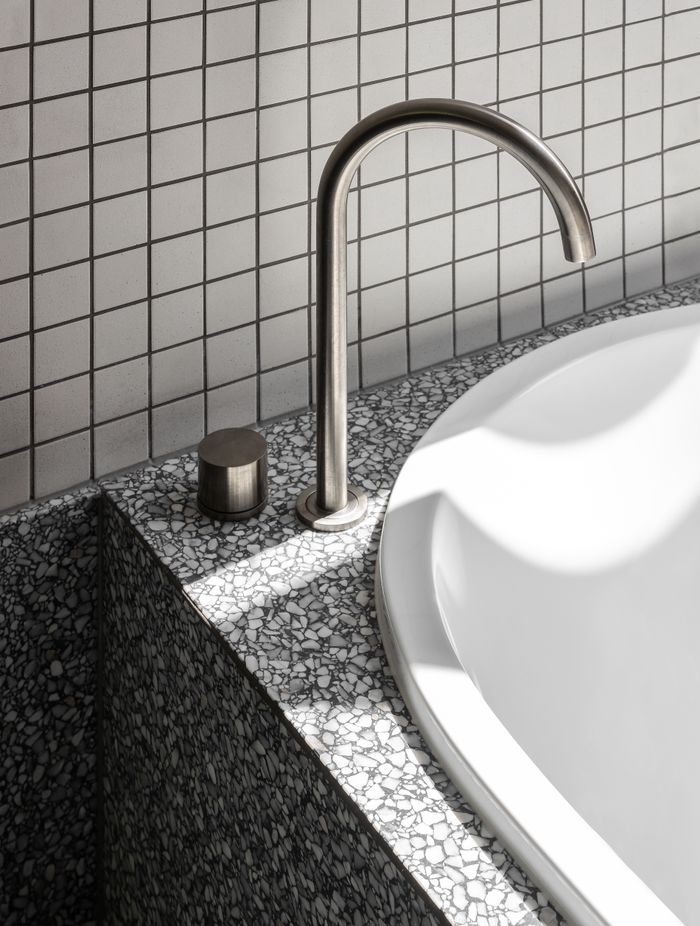 Minimalist hardware allows the tiling and stoneware to shine.
