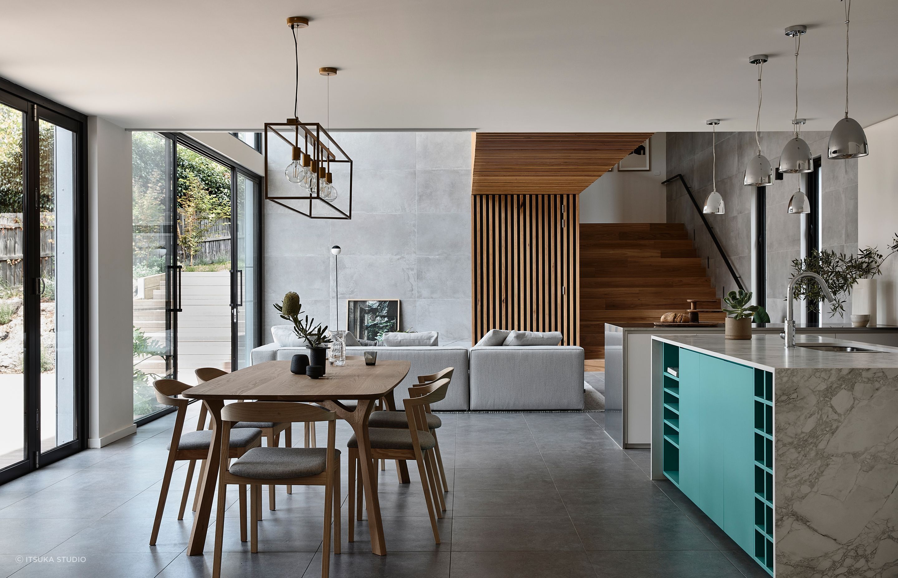 While the timber-clad link bridge is the feature of the double-height living area, a feature has also been made of the kitchen with its vibrant blue accents.