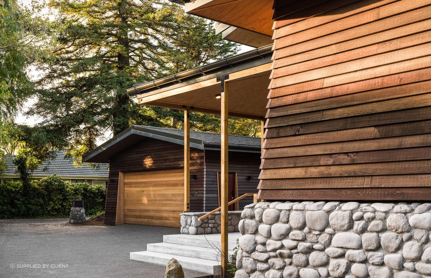 A long driveway marks the transition from the public to the private spaces. Its end reveals a California native, a grand, old redwood tree.
