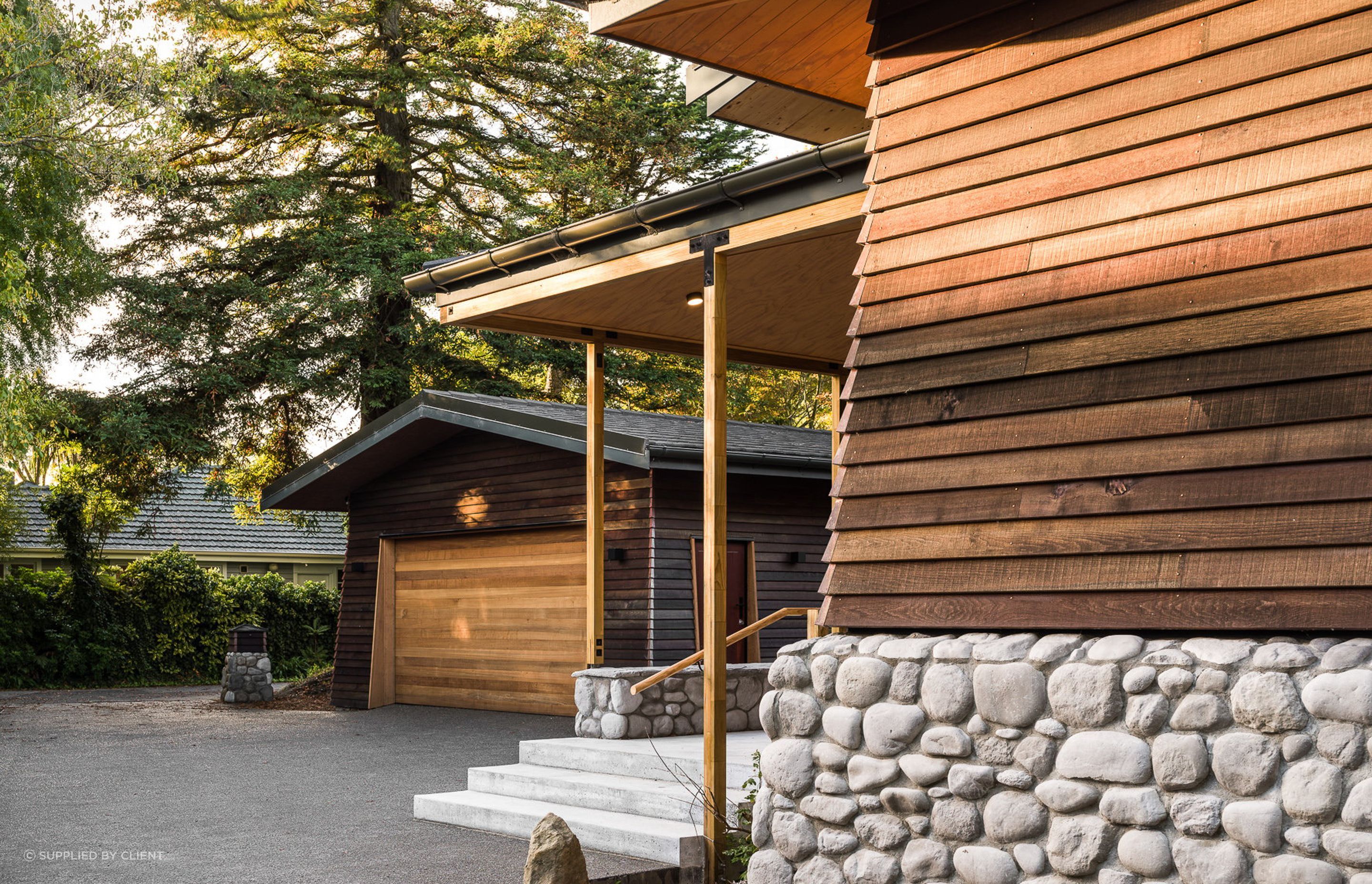 A long driveway marks the transition from the public to the private spaces. Its end reveals a California native, a grand, old redwood tree.