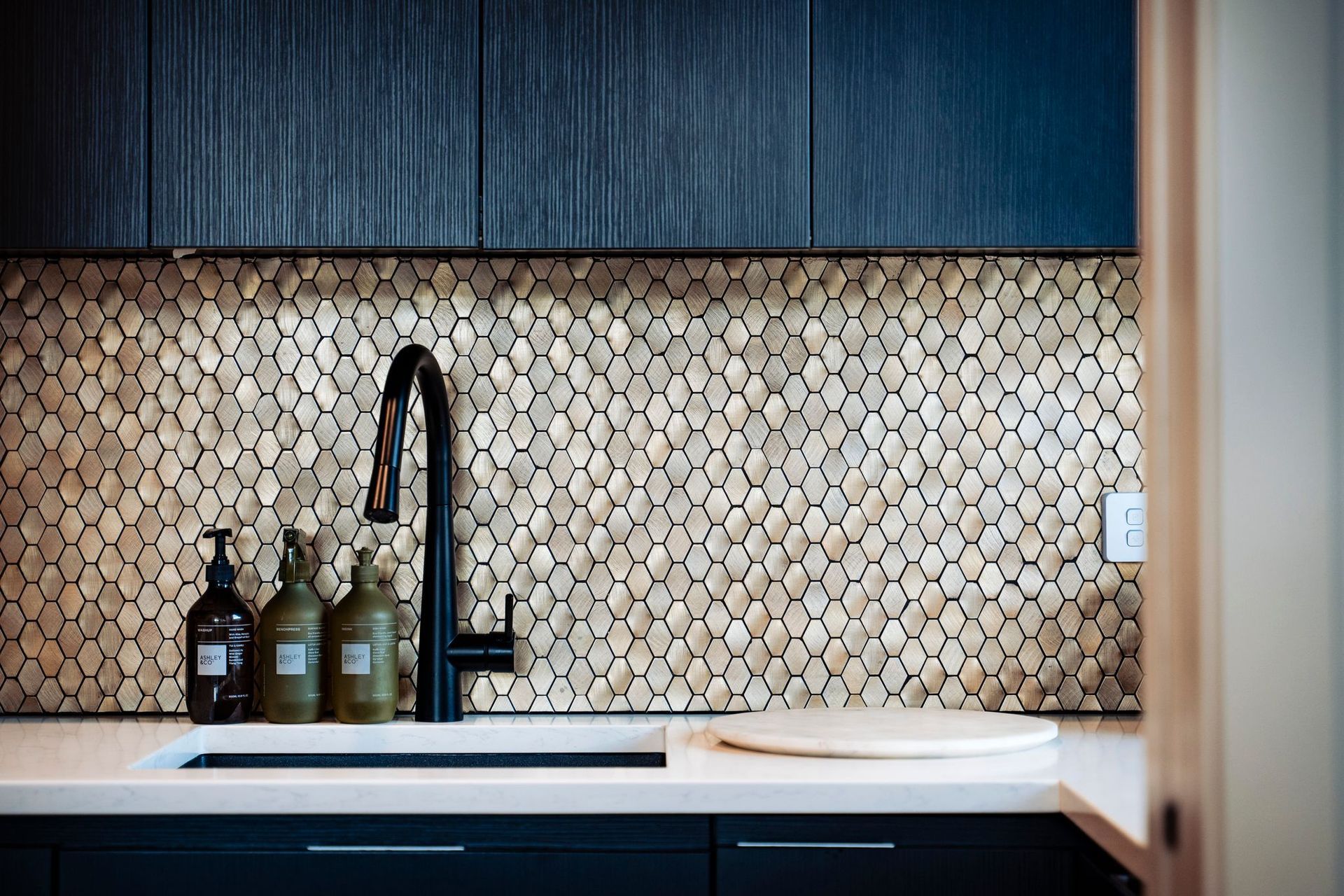 The golden, hexagon-patterned splashback in the scullery brings a touch of luxury.