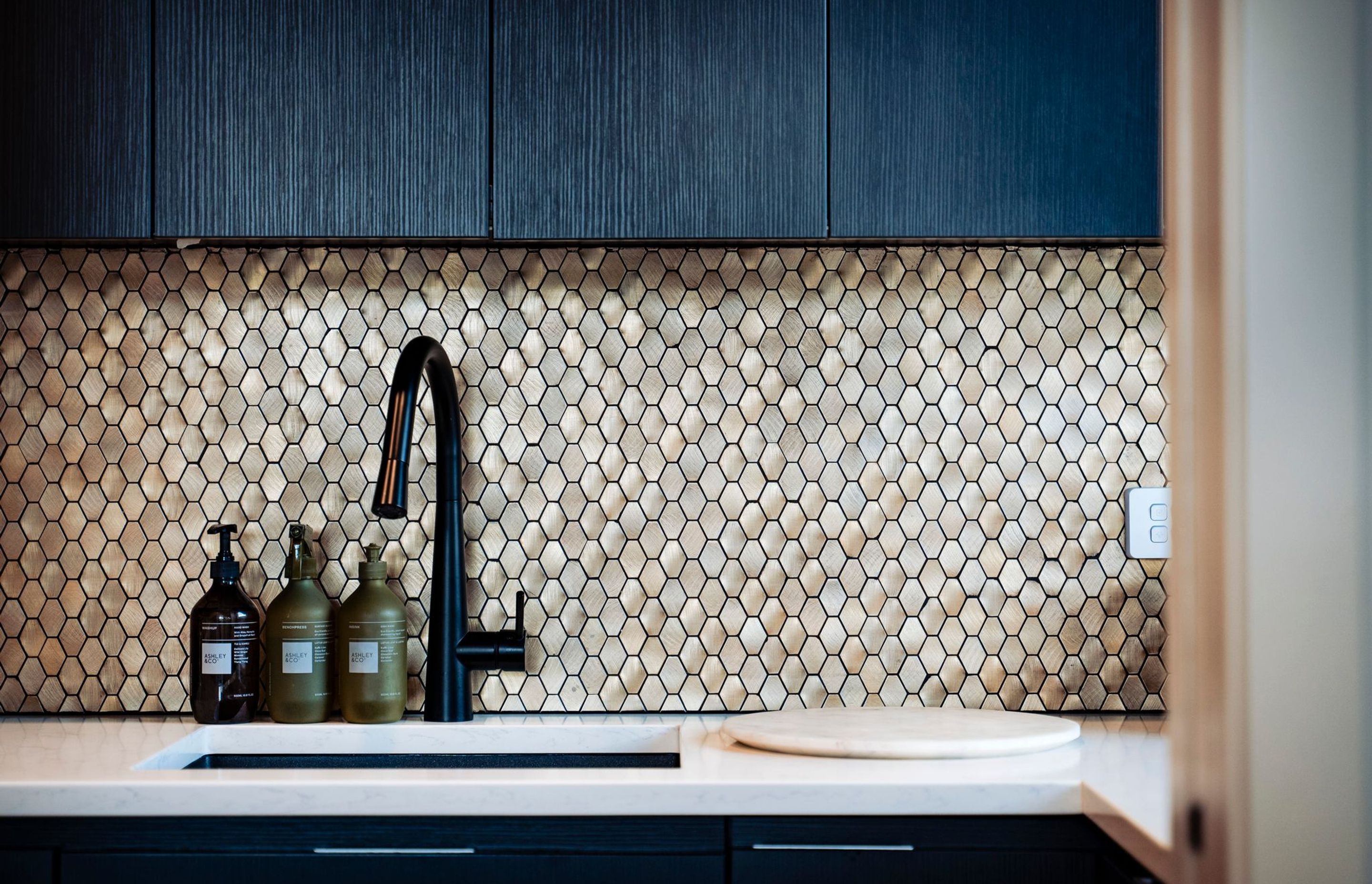 The golden, hexagon-patterned splashback in the scullery brings a touch of luxury.
