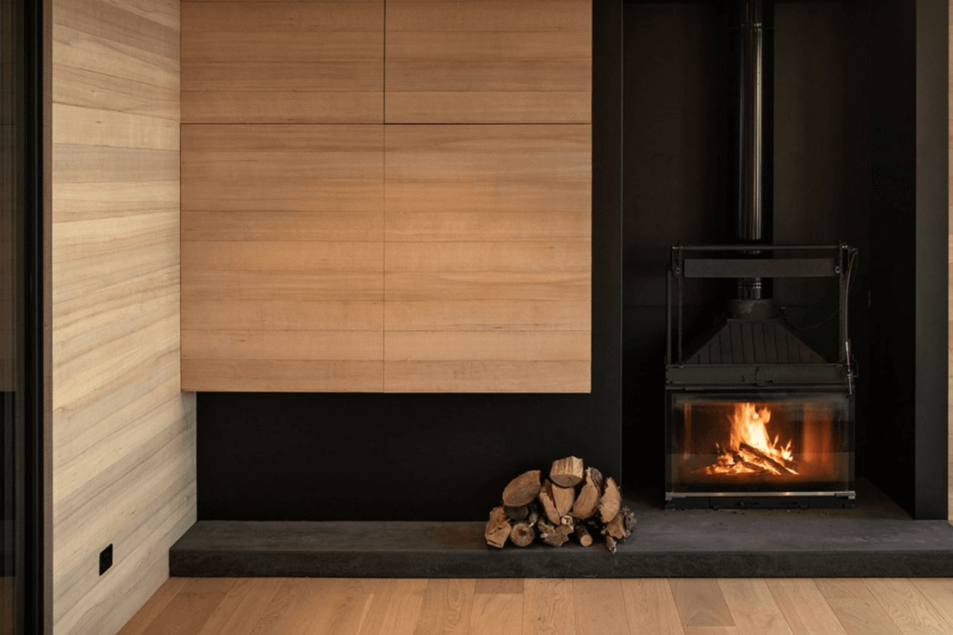 Off the dining space, the living area features plush seating, a wood-burning fireplace, and a television hidden in the cabinetry.