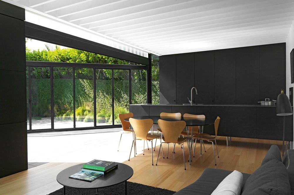The striking black cabinetry dramatically plays against the white exposed rafters bringing a real sense of dimension to the 'Lightbox' kitchen in Ponsonby by Crosson Architects.