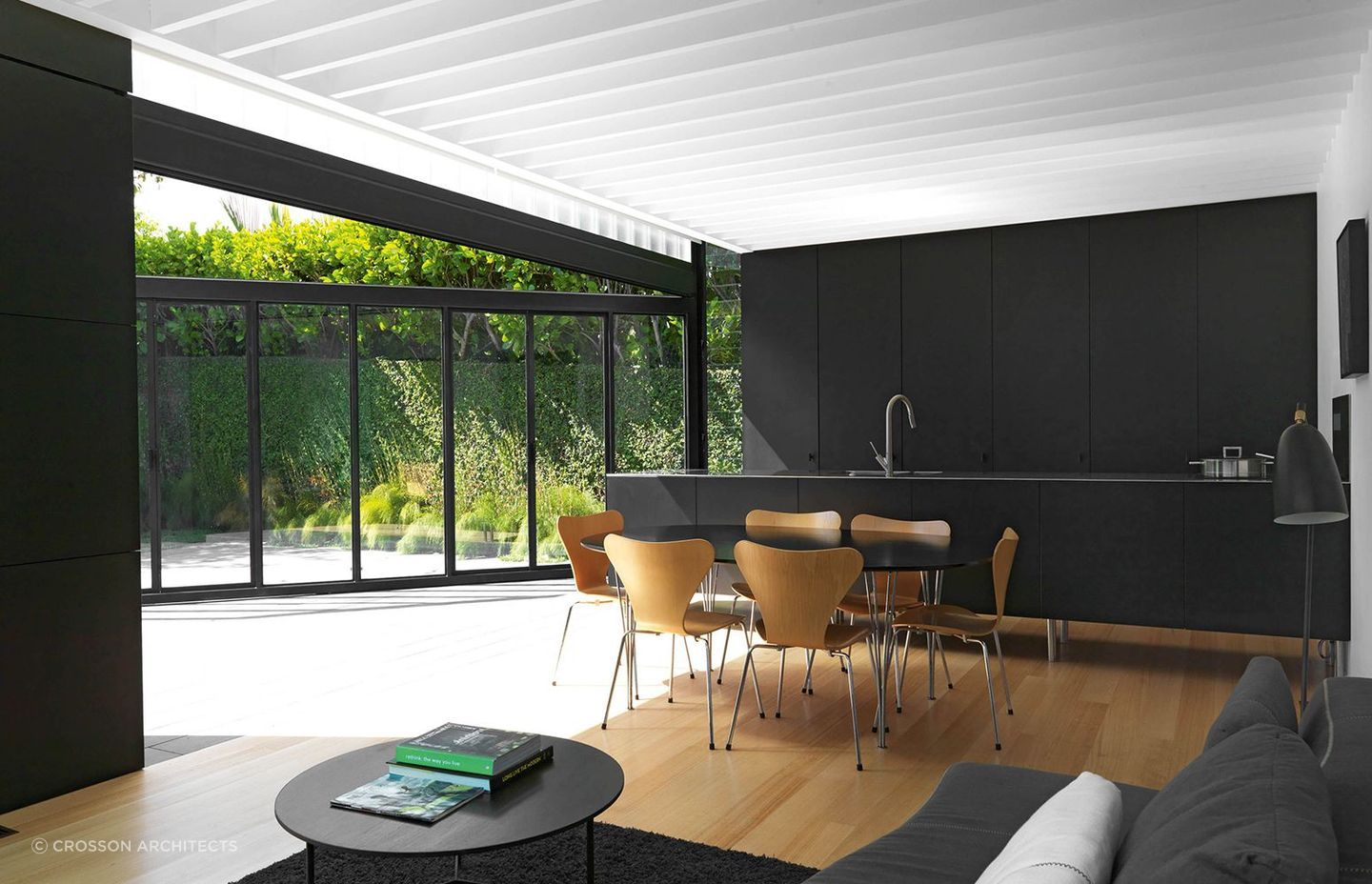 The striking black cabinetry dramatically plays against the white exposed rafters bringing a real sense of dimension to the 'Lightbox' kitchen in Ponsonby by Crosson Architects.