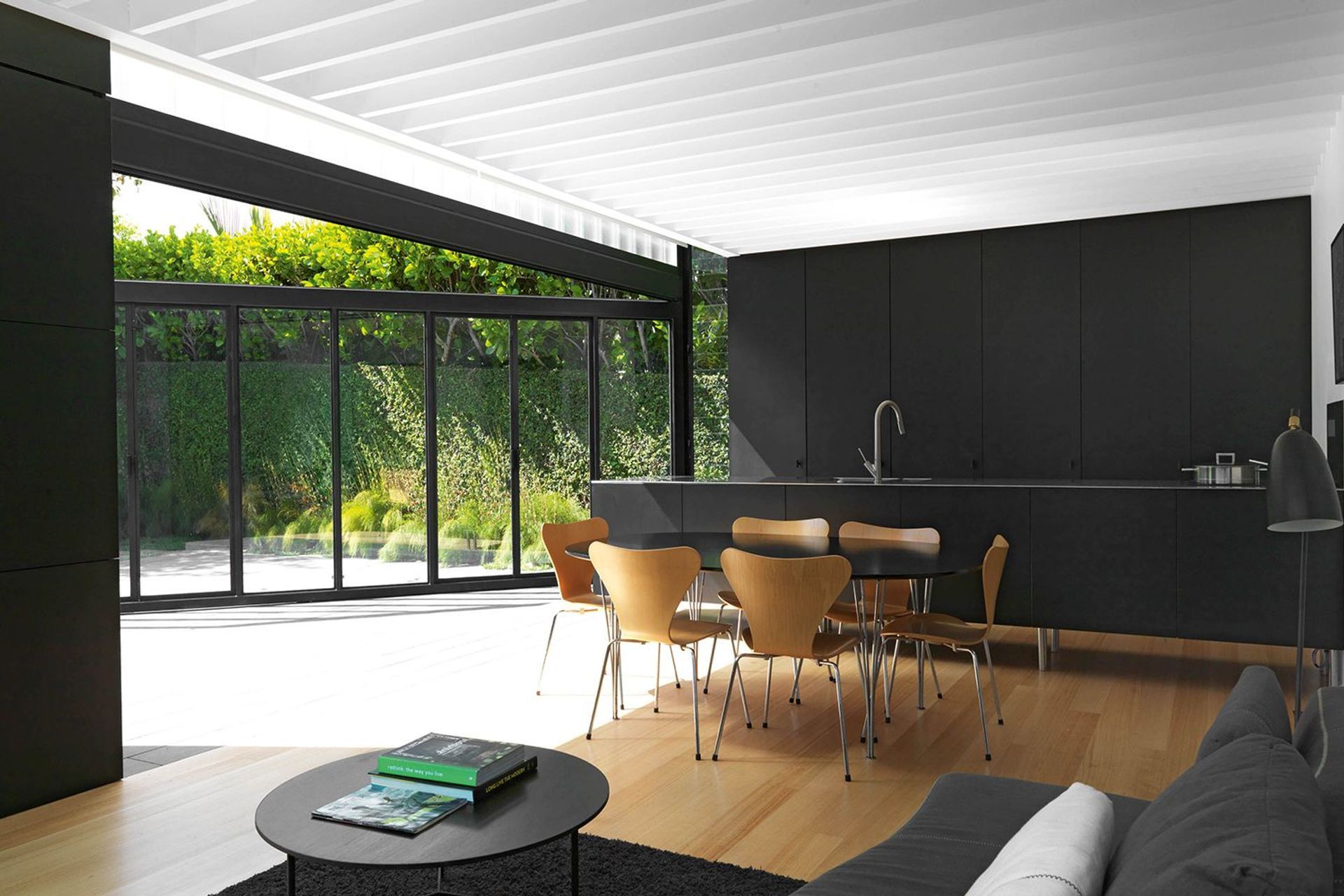 The striking black cabinetry dramatically plays against the white exposed rafters bringing a real sense of dimension to the 'Lightbox' kitchen in Ponsonby by Crosson Architects.