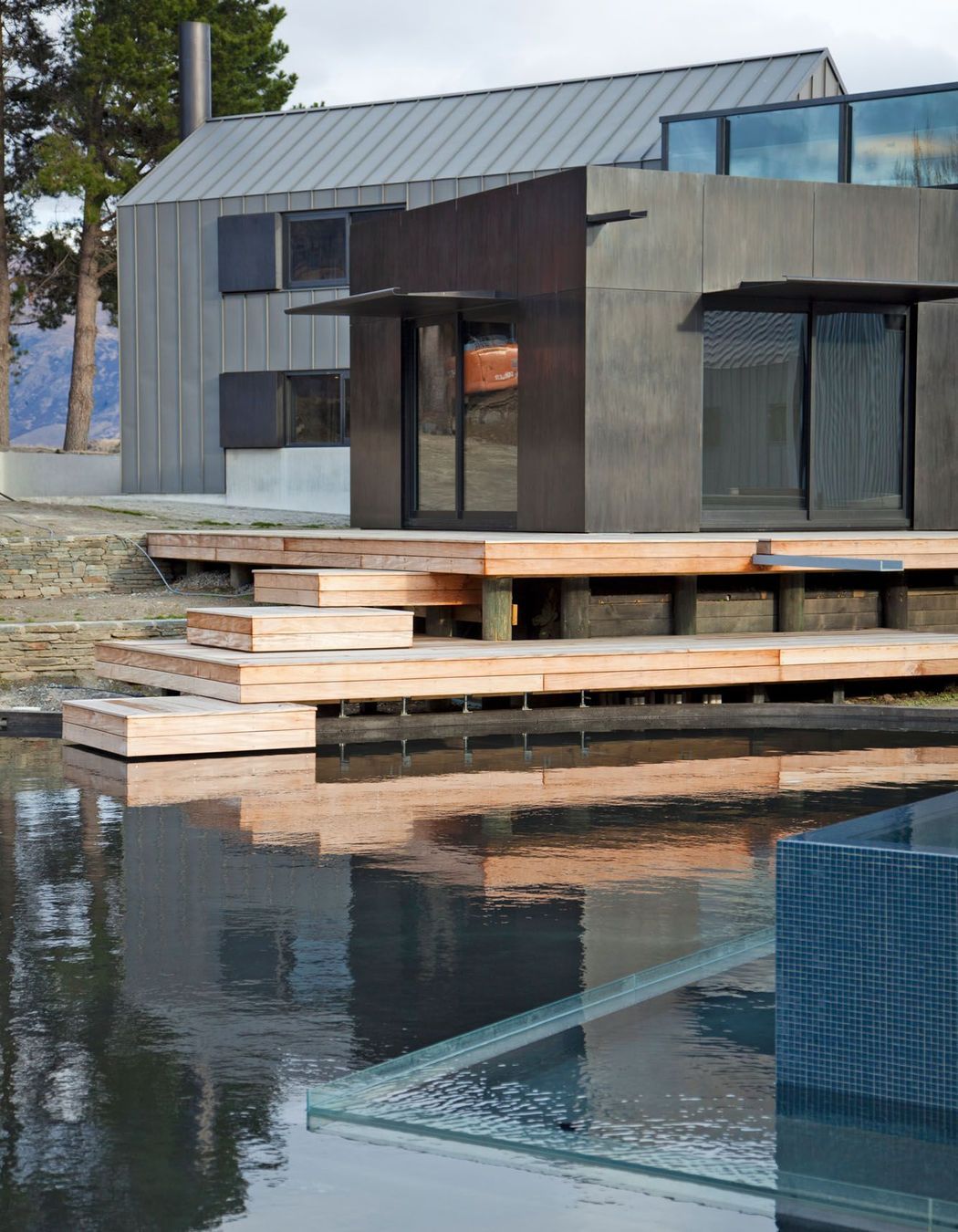 To create the illusion that the water flows into the lake, the walls of the lower pond are made of glass.