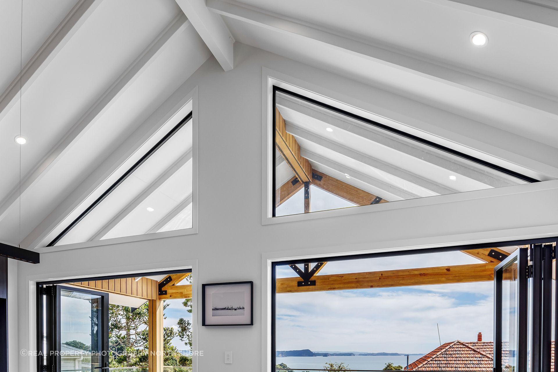 The raked ceiling continues from the open-plan kitchen out over the deck.