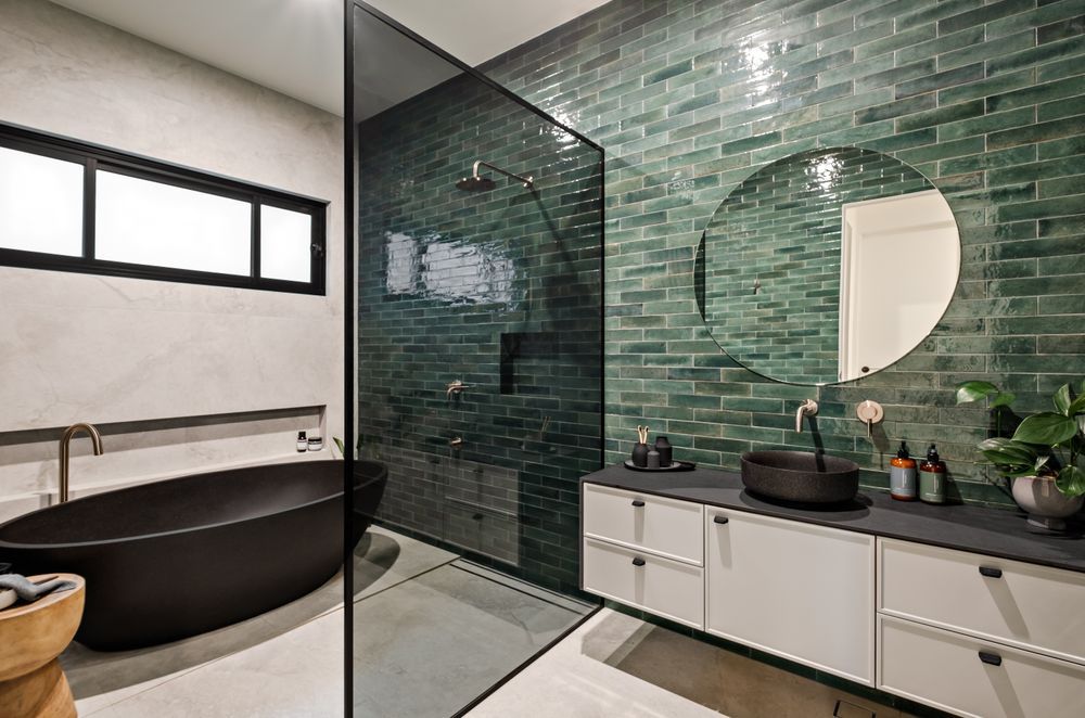 The family bathroom shared by the two younger children also features a green-tiled feature wall.
