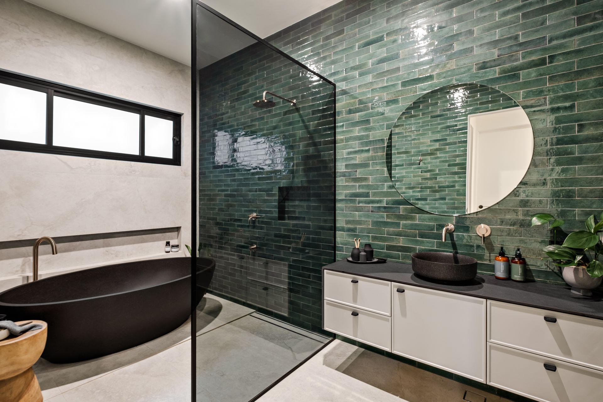 The family bathroom shared by the two younger children also features a green-tiled feature wall.