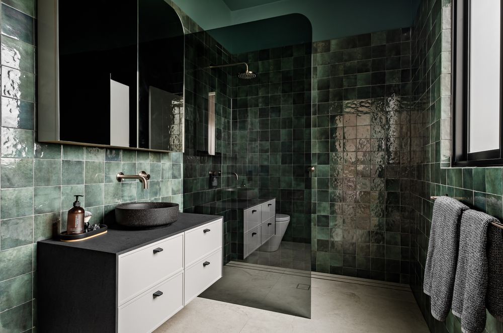 The green tiles in the bathroom create a rich and luxury palette and were chosen for the clients' love of green.