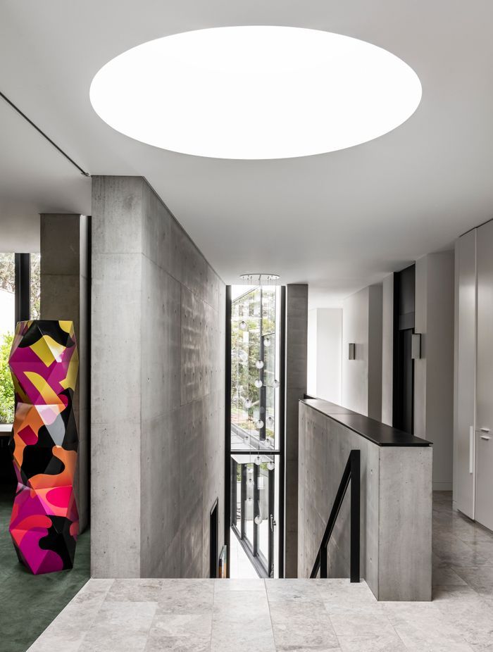 A stair running through the three storeys is spliced between the concrete blades.
