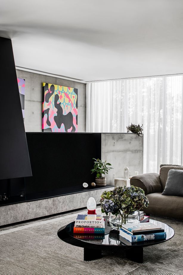 A gas fireplace is built into a pony wall in the living space, providing a cosy spot to gather.