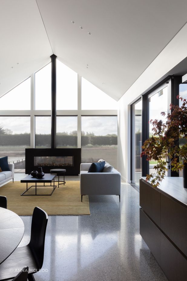 The main living room, anchored by a custom-built fireplace with a seamless flue | Photographer: Anna McLeod