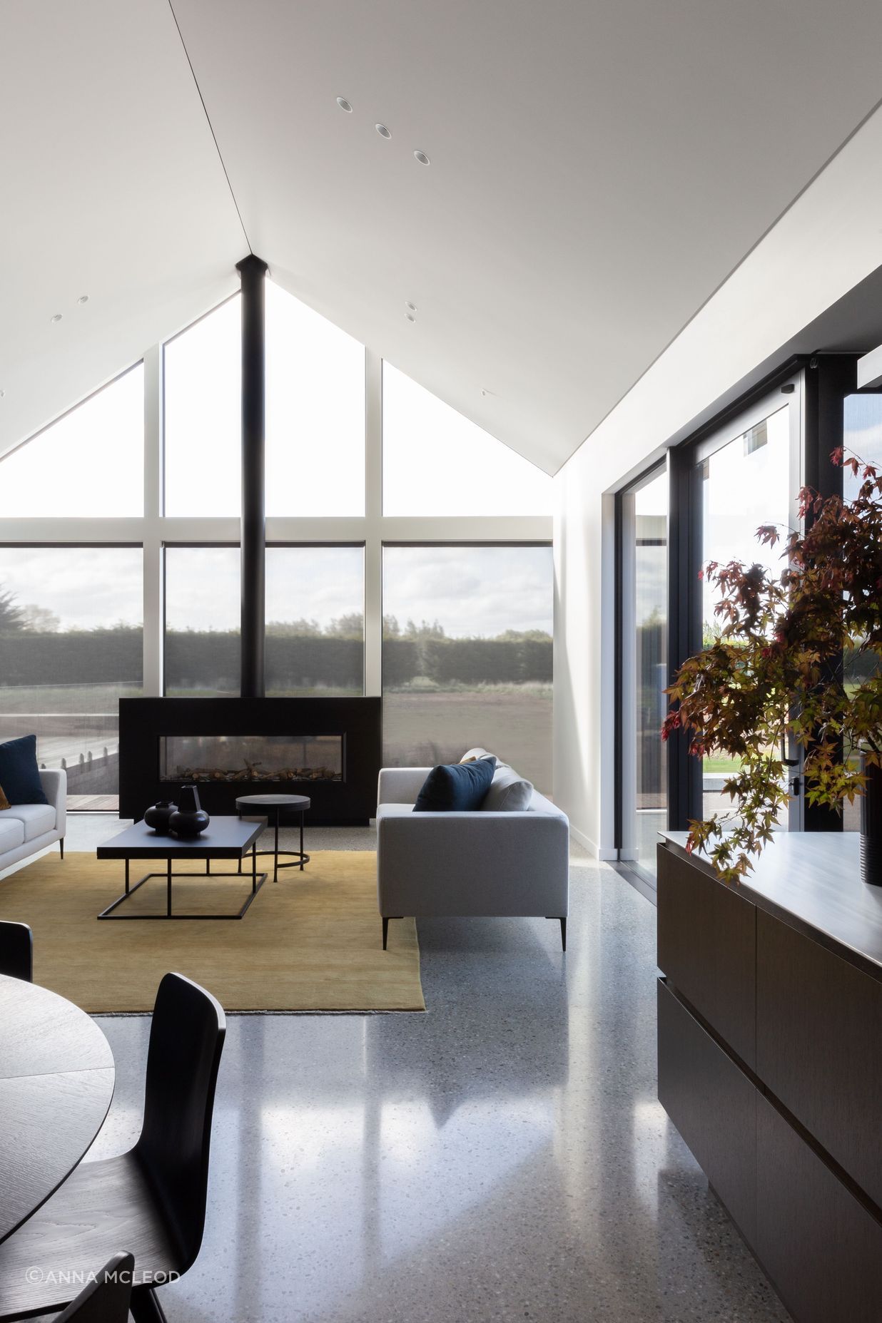 The main living room, anchored by a custom-built fireplace with a seamless flue | Photographer: Anna McLeod