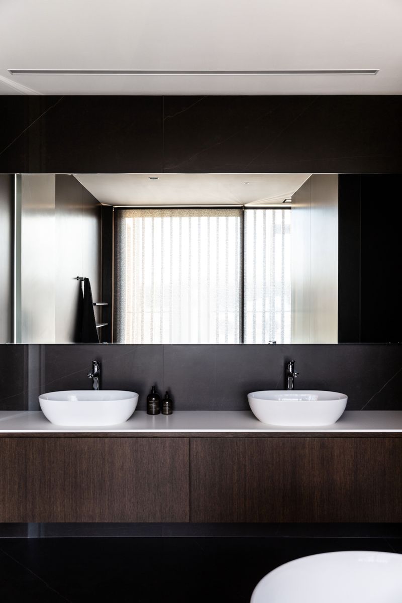 The main bathroom; expressing the same elegance and chocolate brown cabinetry as seen in the kitchen | Photographer: Anna McLeod