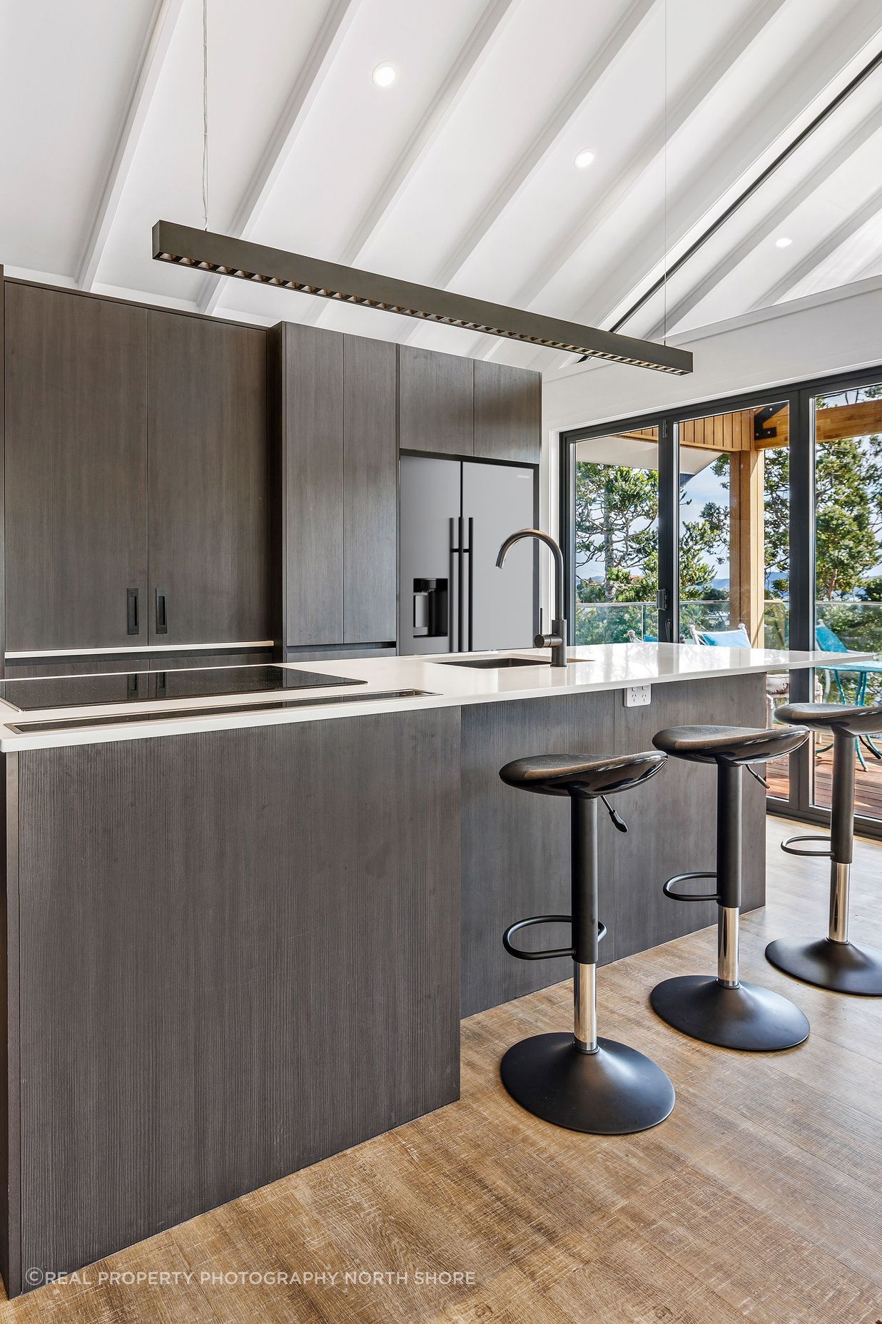 The white raked ceiling gives the kitchen a bright, spacious feel.