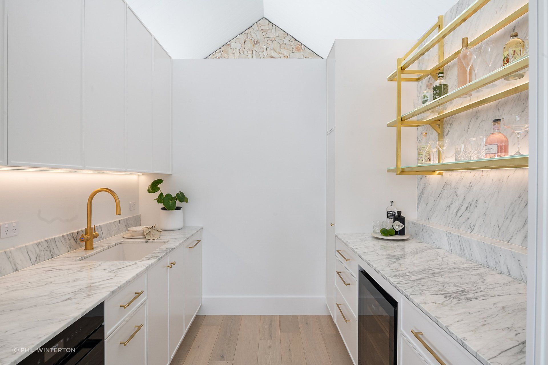 Brass finishes contrasts with marble in the butler's pantry.