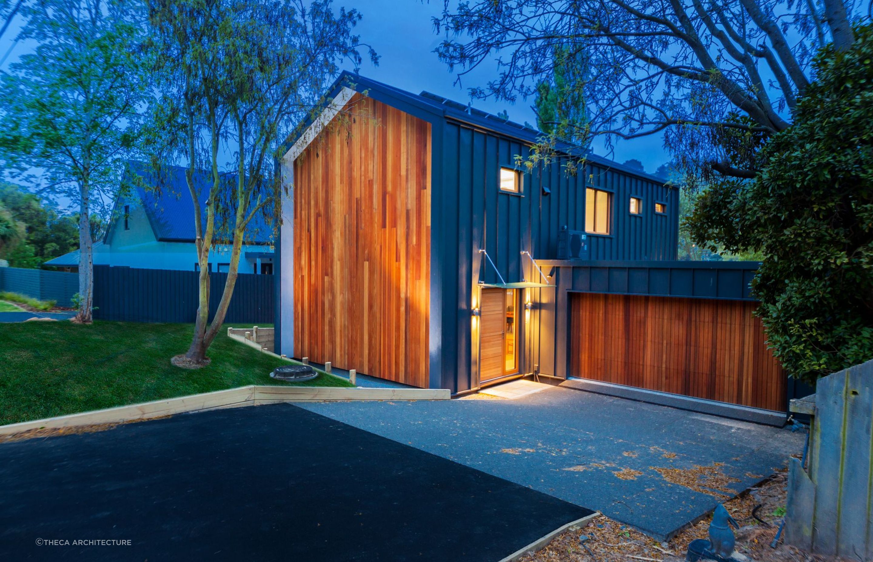 The entryway of the Pitkin-Douglas Passive House at night where solar panel-cladding can be seen on the north-facing roof.