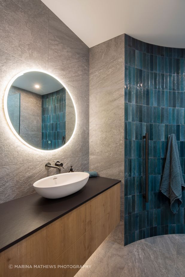 The guest bathroom features a curved wall with tiles that reflect the blues of the Clutha River.