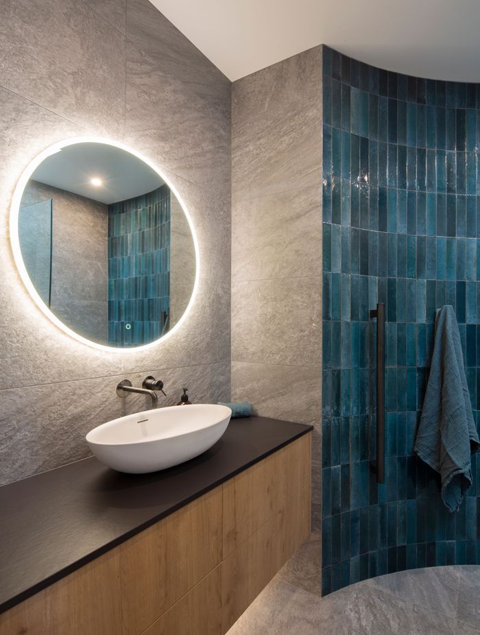 The guest bathroom features a curved wall with tiles that reflect the blues of the Clutha River.