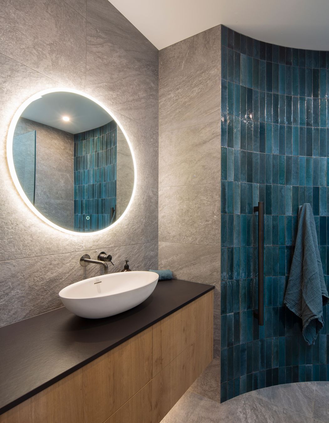 The guest bathroom features a curved wall with tiles that reflect the blues of the Clutha River.