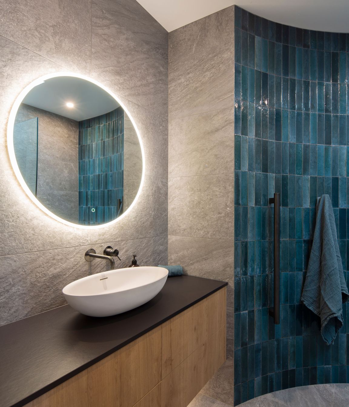 The guest bathroom features a curved wall with tiles that reflect the blues of the Clutha River.