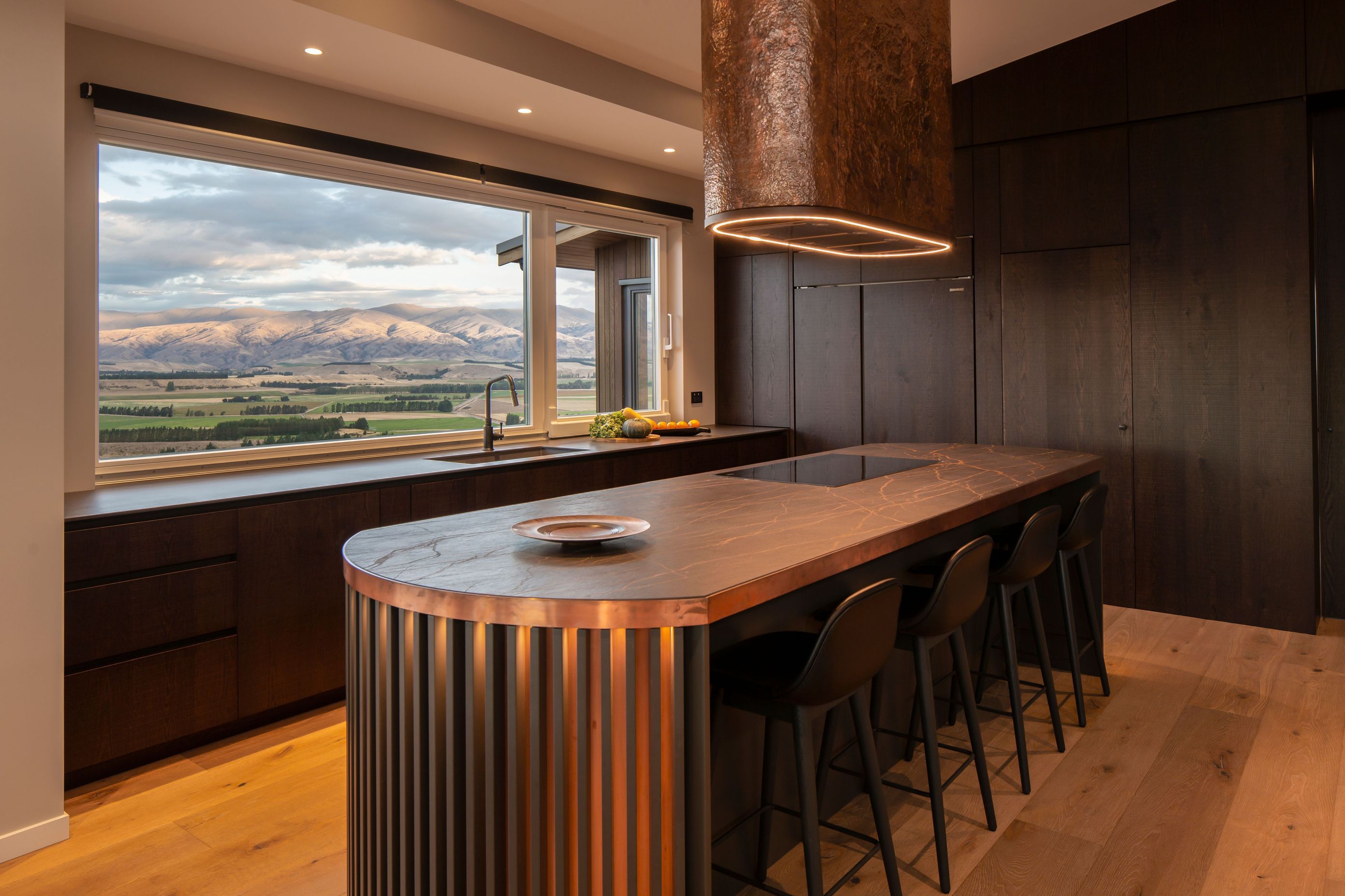 The stunning handcrafted kitchen showcases the copper rangehood by a local artisan.
