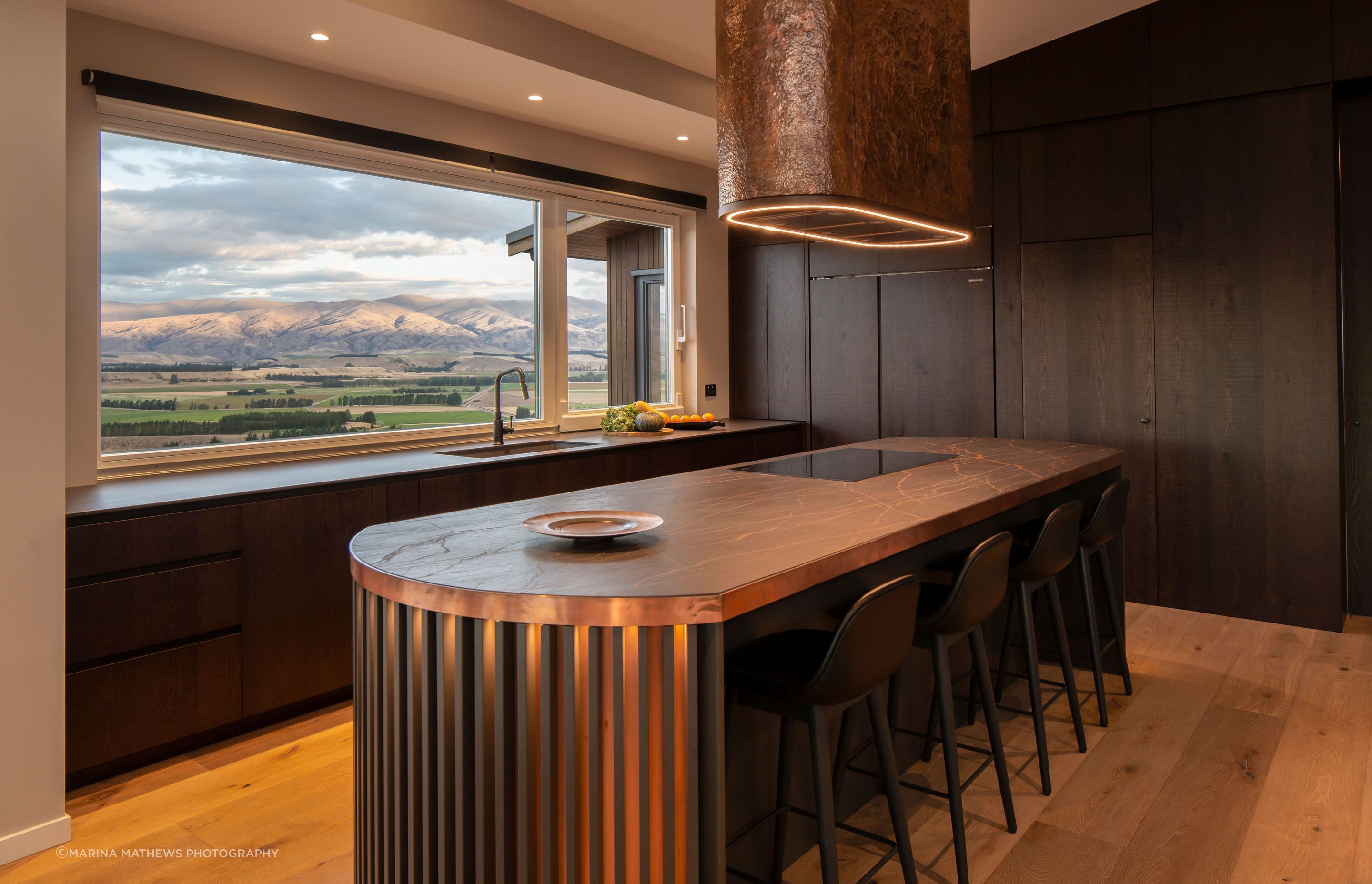The stunning handcrafted kitchen showcases the copper rangehood by a local artisan.