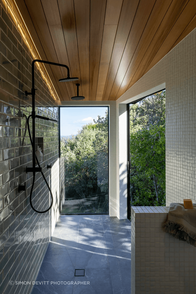 The master room’s ensuite extends into a spacious walk-in shower, with a large sliding door to the right that appears as a window.