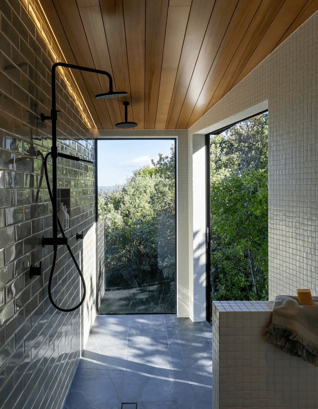 The master room’s ensuite extends into a spacious walk-in shower, with a large sliding door to the right that appears as a window.