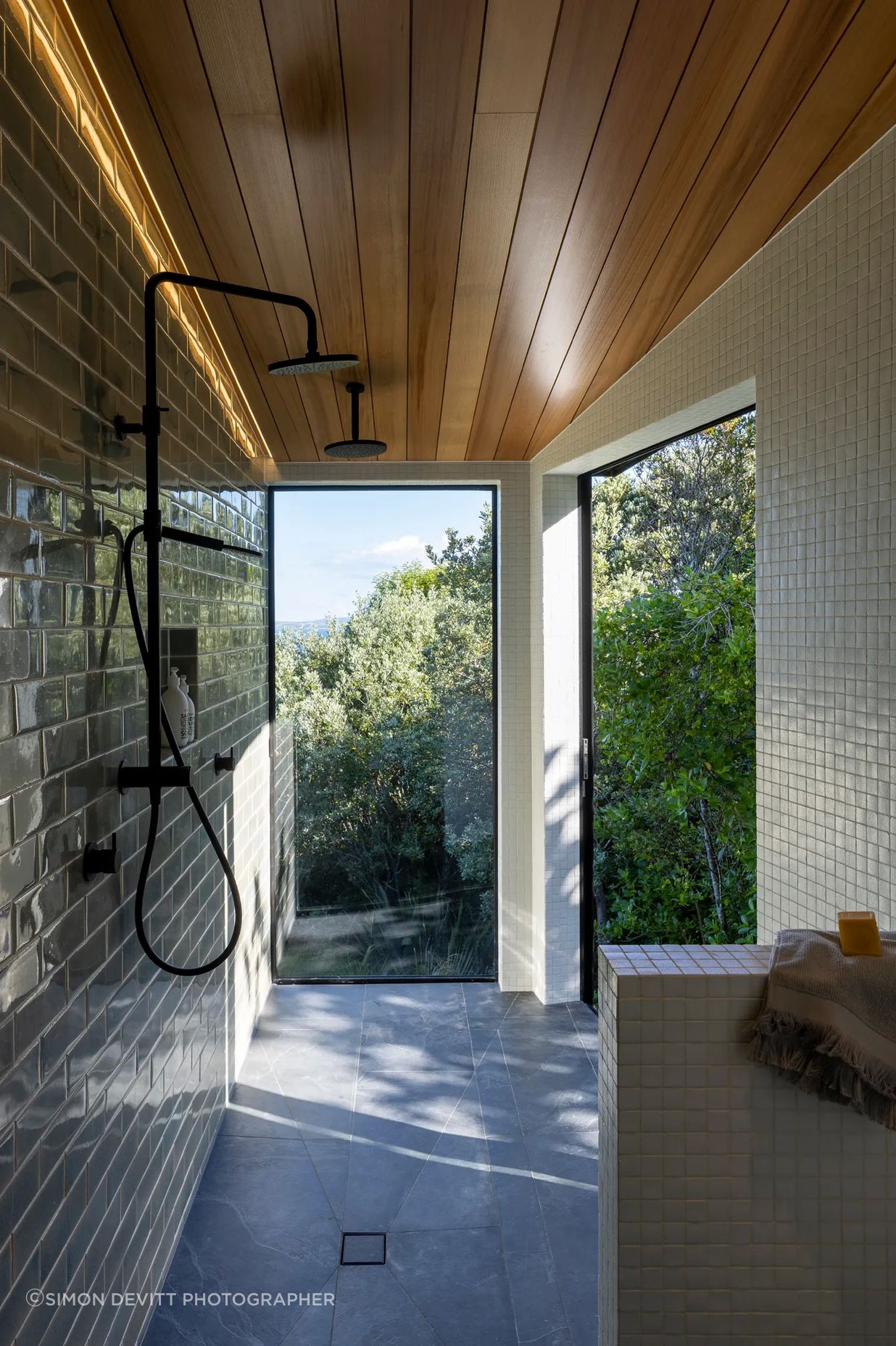 The master room’s ensuite extends into a spacious walk-in shower, with a large sliding door to the right that appears as a window.