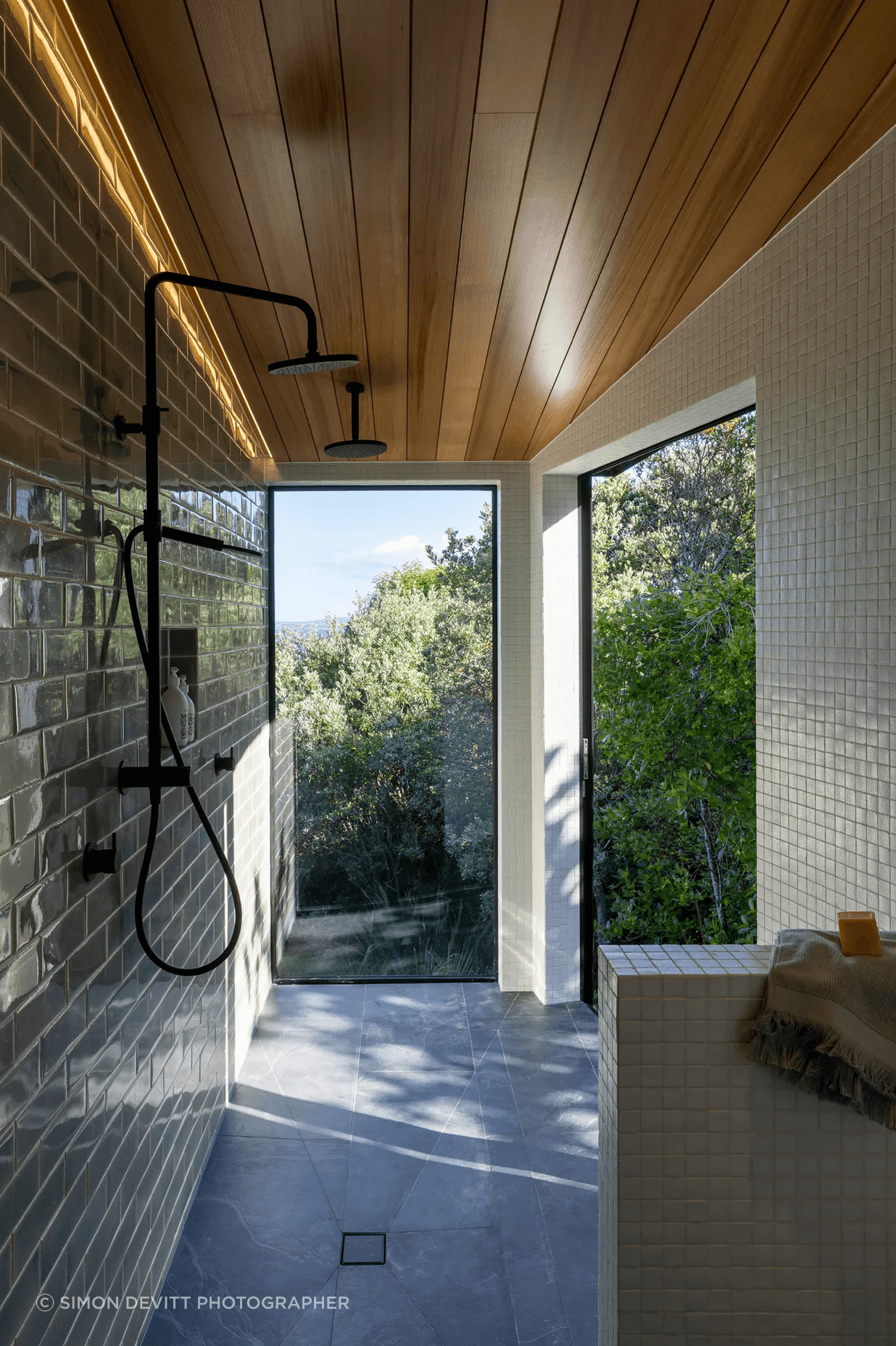 The master room’s ensuite extends into a spacious walk-in shower, with a large sliding door to the right that appears as a window.