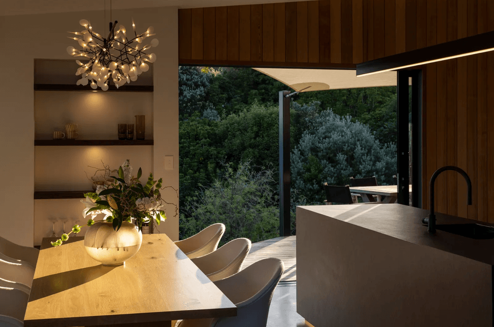 The open-plan kitchen and dining room, extending into the quiet surrounds with a sheltered outdoor living space.