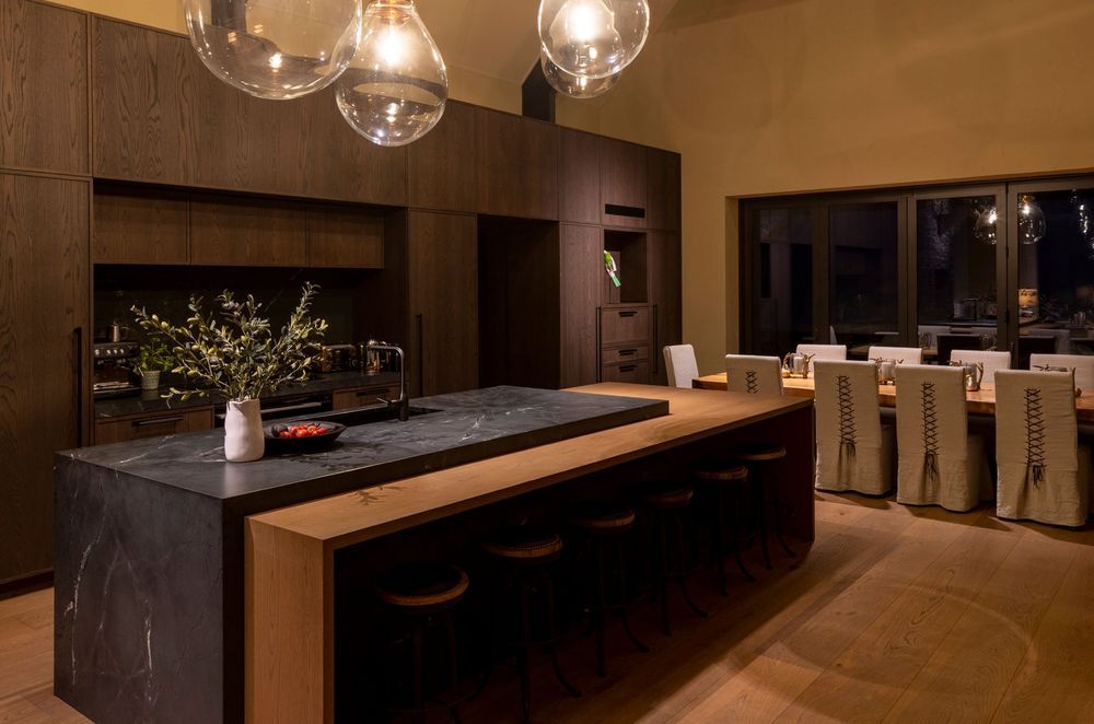 “The dining table is a swamp kauri slab from Dargaville, which was found early on and then a base was constructed for it. The dining chairs were custom made with leather detailing on the back,” says Vee.
