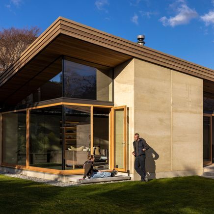 The rammed earth house with a curved roof that lifts toward the sun